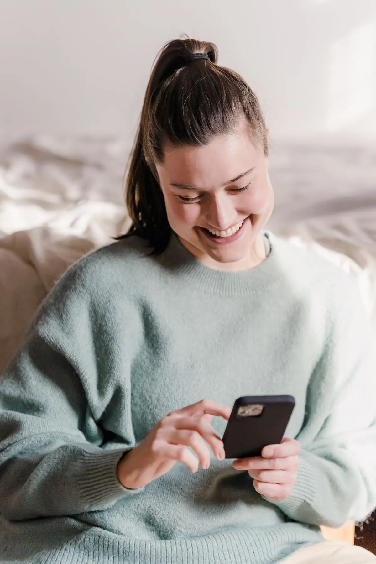 A relieved woman smiling at home after handling an urgent expense